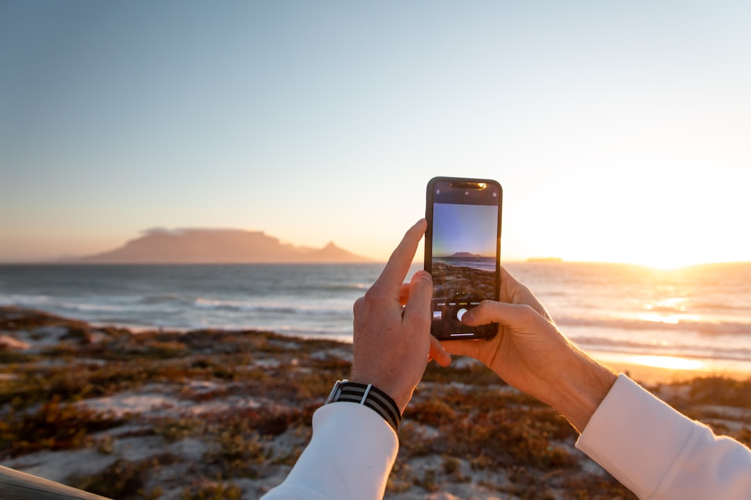 person holding iphone 6 taking photo of sea during daytime