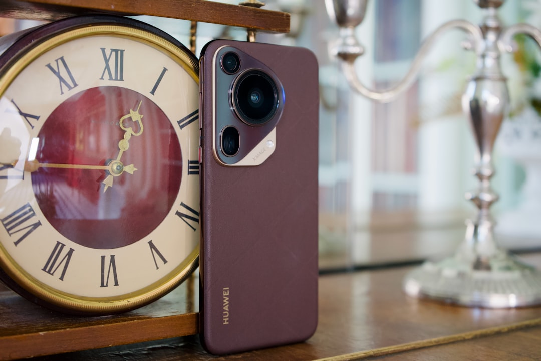 a close up of a cell phone near a clock
