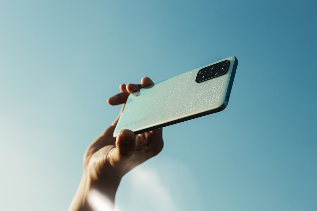 a person holding a cell phone up in the air